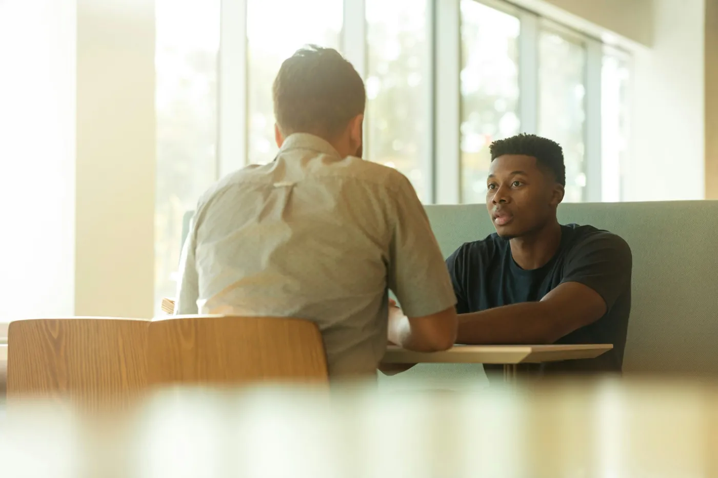 A supportive conversation between a student and a mentor in a welcoming setting
